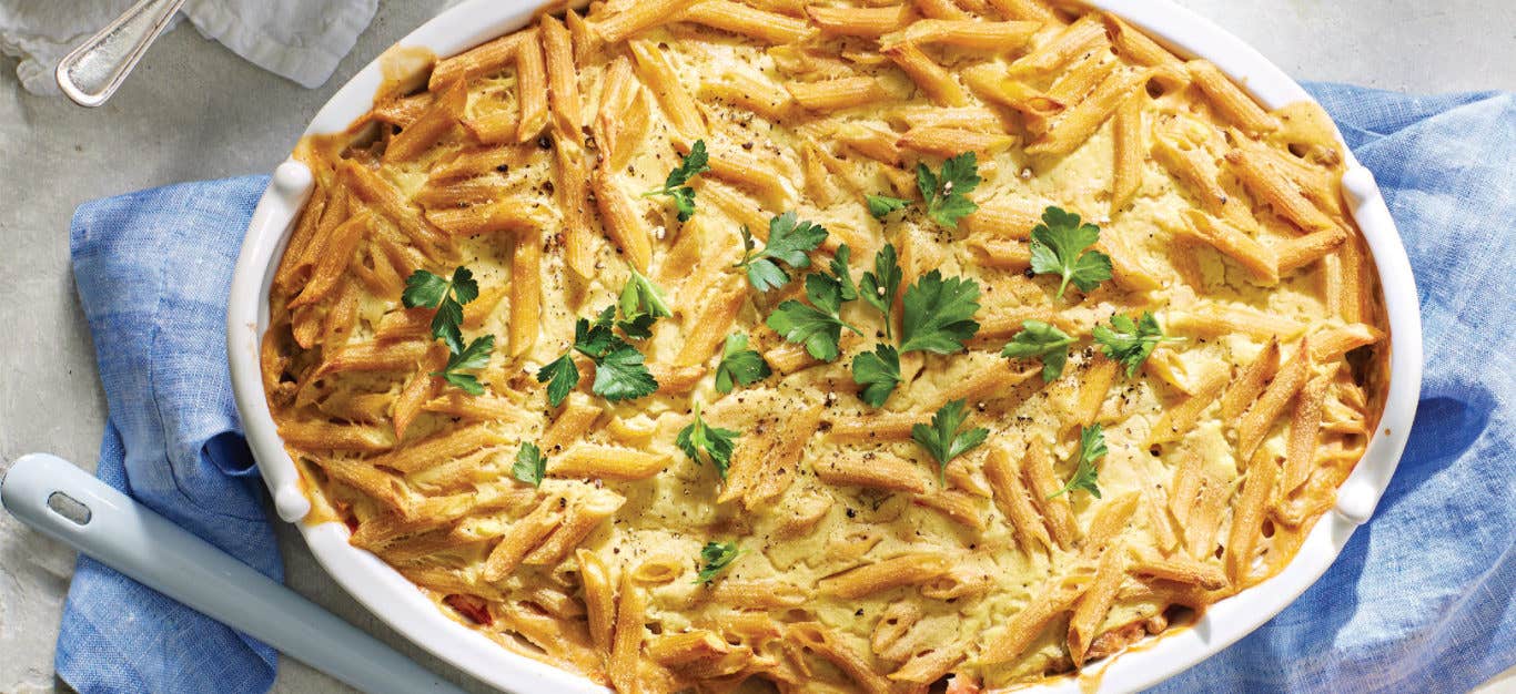 Vegan Pastitsio με φακές (ελληνική λαζάνια) σε ένα λευκό πιάτο κατσαρόλας γαρνιρισμένο με επίπεδη μαϊντανό φύλλα