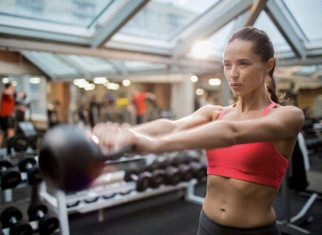 Γυναίκα που εκτελεί κούνιες kettlebell, επιδεικνύοντας τις καλύτερες τεχνικές αναπνοής για την επεξεργασία