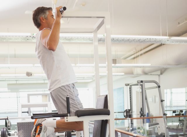 ώριμος άντρας που κάνει pull-ups στο γυμναστήριο