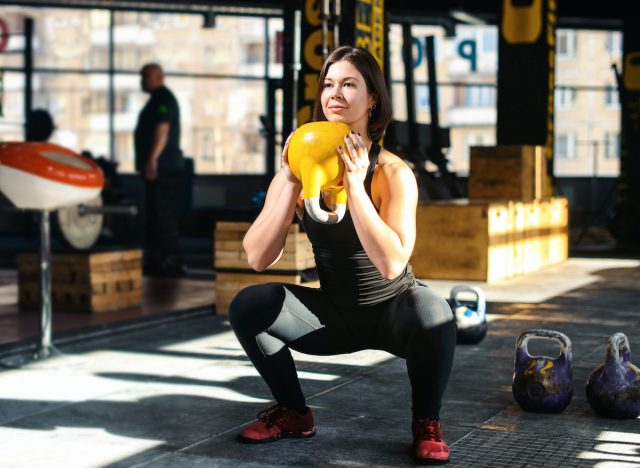 Γυναίκα που κάνει kettlebell goblet squats ασκήσεις κατάρτισης βάρους για απώλεια βάρους στο γυμναστήριο