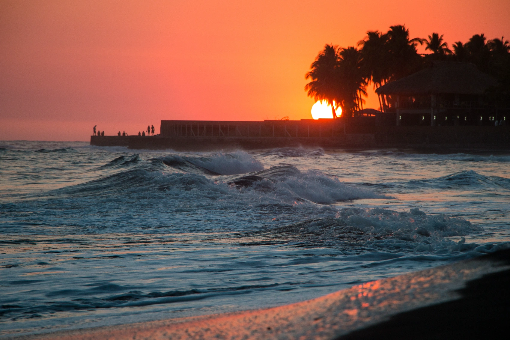 El Tunco, Ελ Σαλβαδόρ Sunset View of El Tunco Beach, με τους Silouhetted People που περπατούν σε μια αποβάθρα, Ελ Σαλβαδόρ